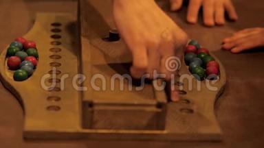 成人手展示游戏规则用木制彩球，特写..